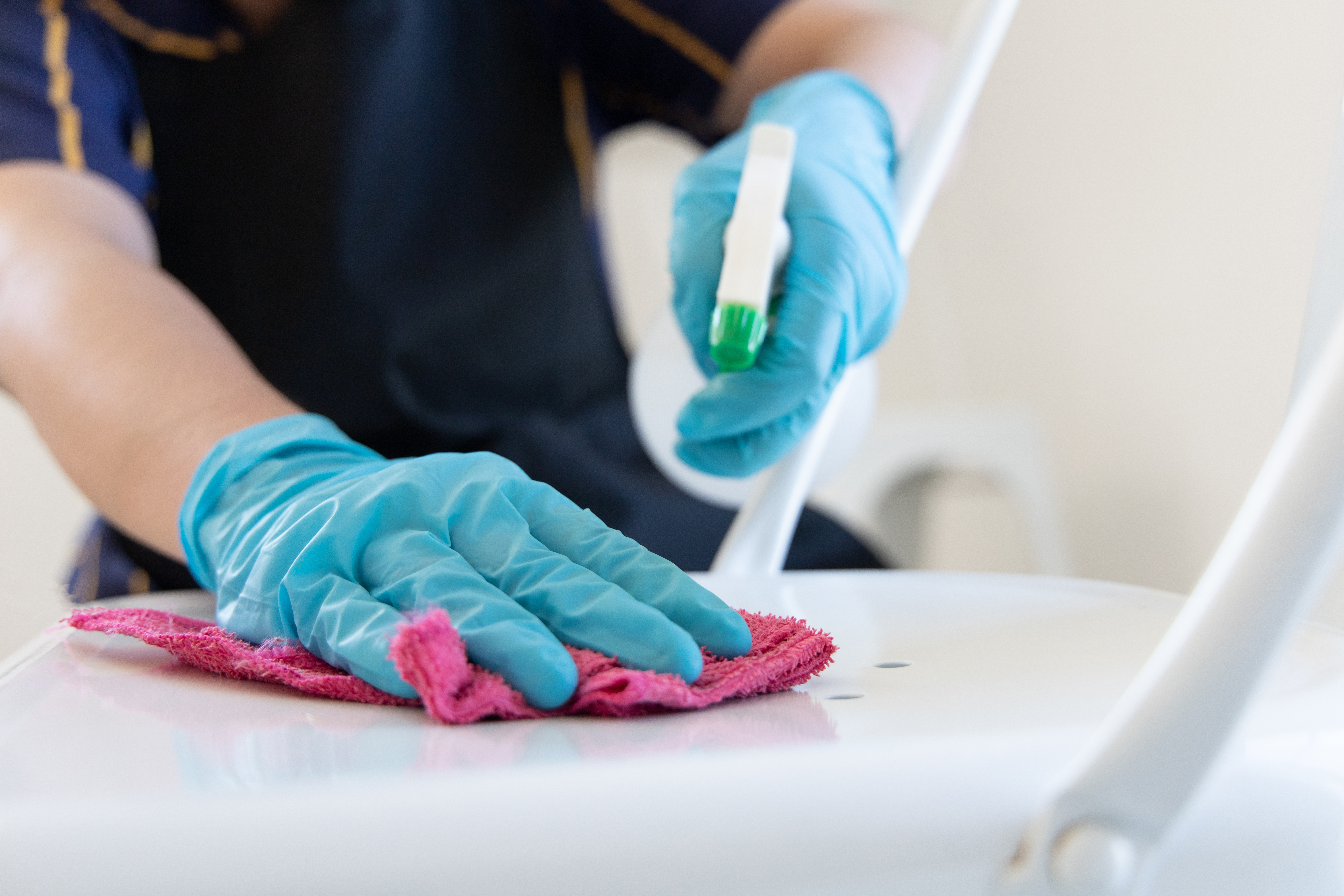 A close up of a cleaner spraying cleaning products onto a surface to show why you should stock up on cleaning supplies for easter holiday deep cleans.