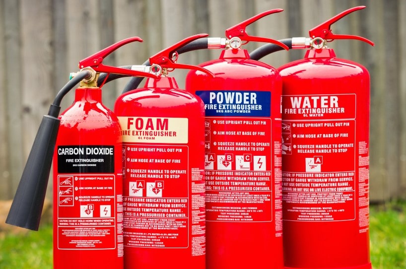Different fire extinguishers that all have different colour codes.