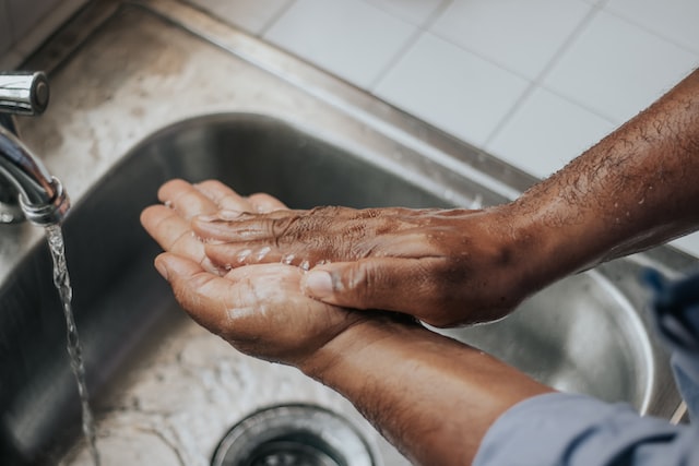 Man Washing his hands with hygiene supplies